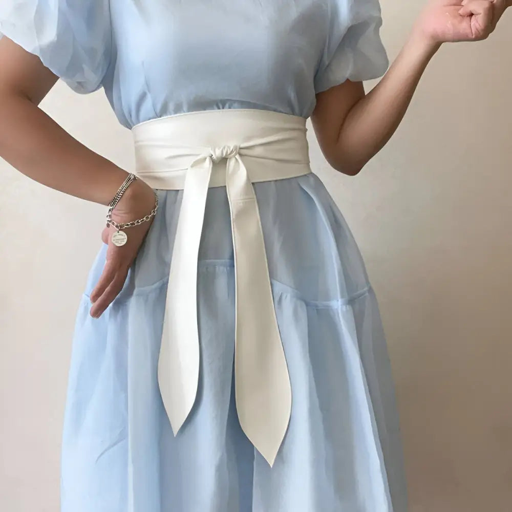 Light blue dress with white sash featuring the Elly Belt in brown and black leather