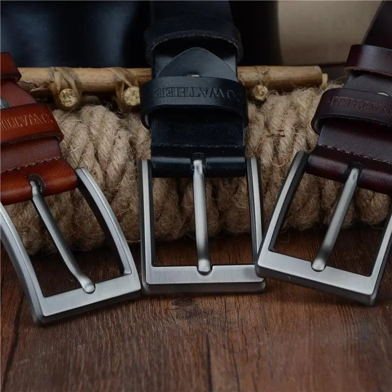 Three leather belts with metal buckles displayed alongside a Blue Camouflage Sweater for Men