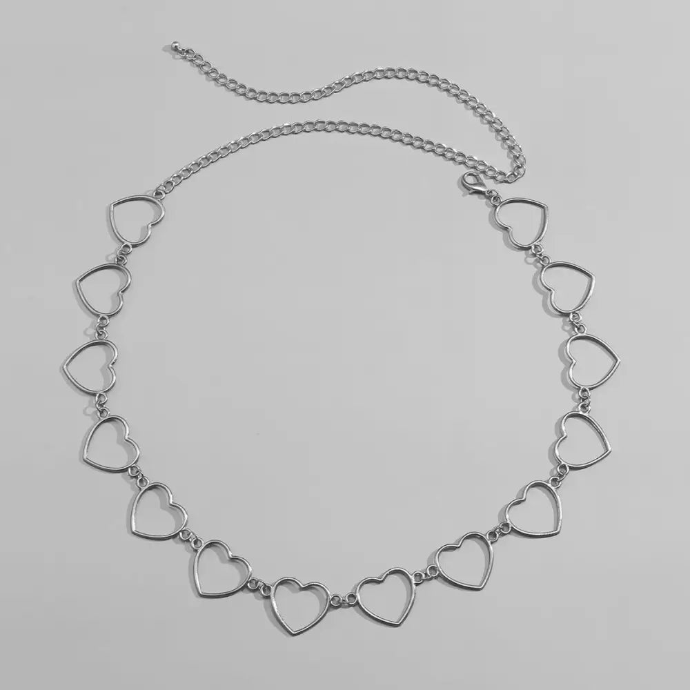 Silver heart-shaped chain belt accessory for black pleated skirts