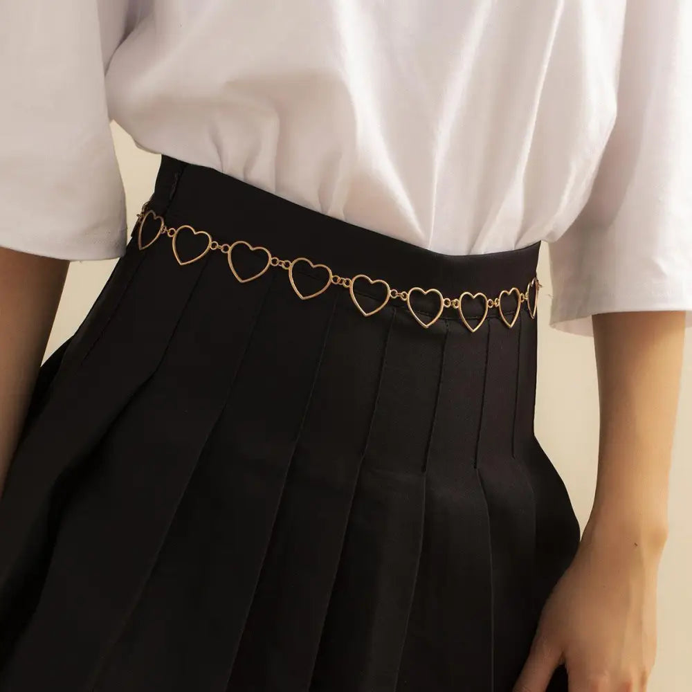 Gold heart chain belt accessory designed for black pleated skirts for stylish elegance