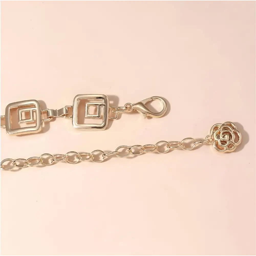 Gold-toned Chemeris Chain Belt with square links and floral accents for elegant style