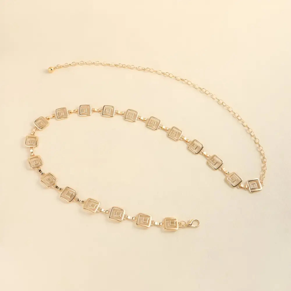 Gold-toned chemeris chain belt with square links and hanging chains for stylish wear