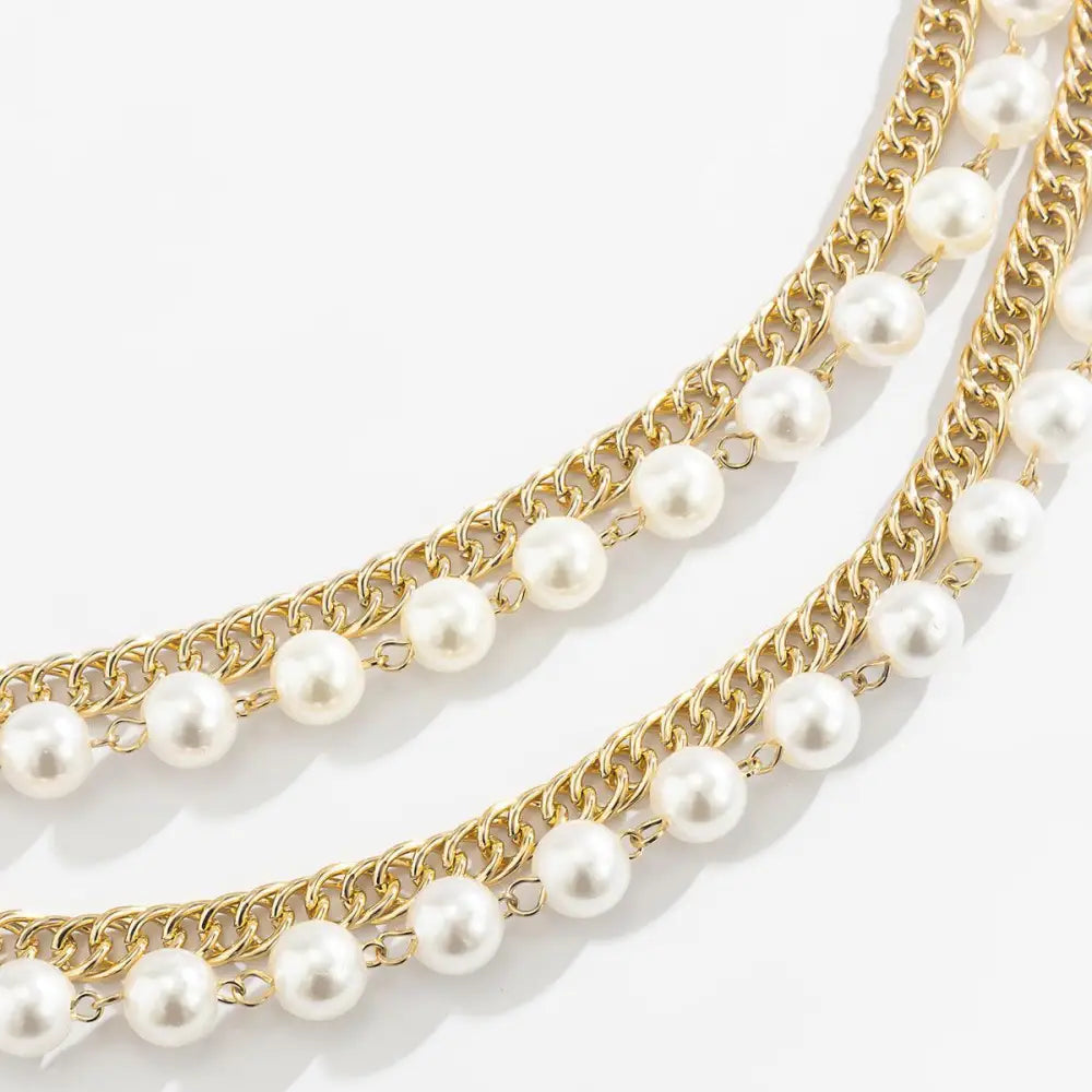 Gold chains with pearl accents featured on Black Dress with Iomache Chain and Pearl Belt