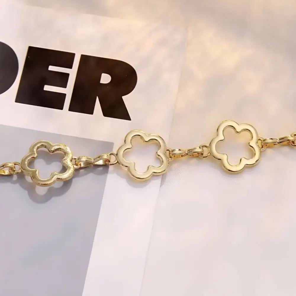 Gold flower-shaped chain accessory complementing Light Blue High-Waisted Jeans with Gold and Silver Chain Belts