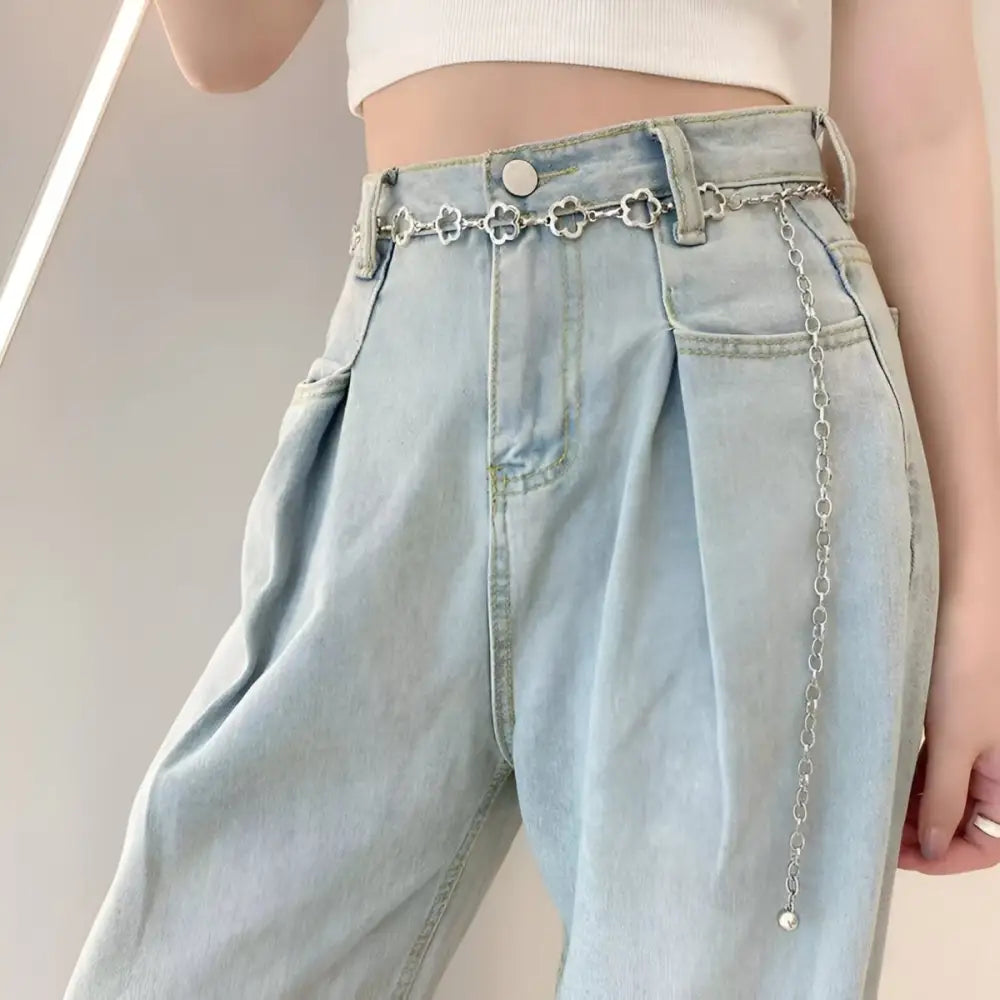 Light blue high-waisted jeans with silver chain belt showcasing trendy denim fashion