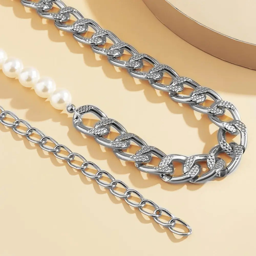 Silver chain belt necklace with pearls displayed alongside Faux Leather Dresses with Pearl Accents