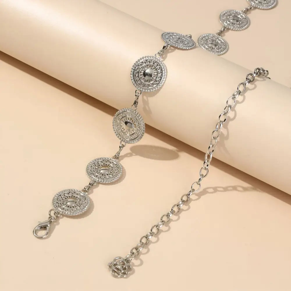 Silver Orya chain belt with circular medallions enhancing aesthetic appeal for black mini skirts
