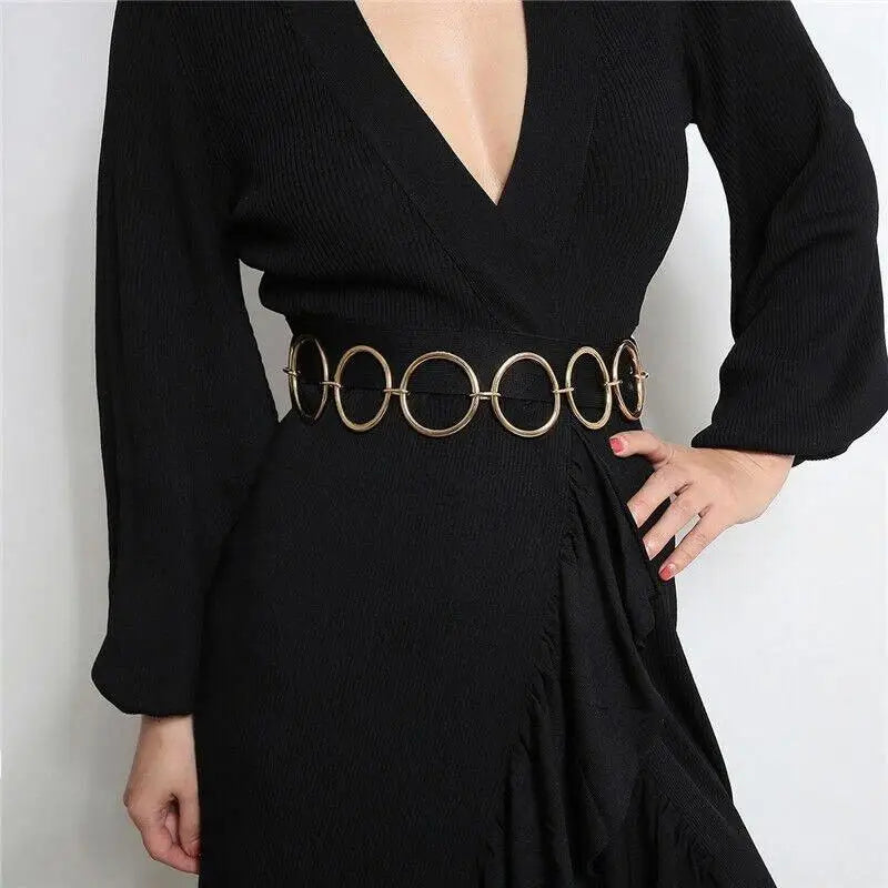Black dress with a gold circle chain belt, enhancing elegance and style