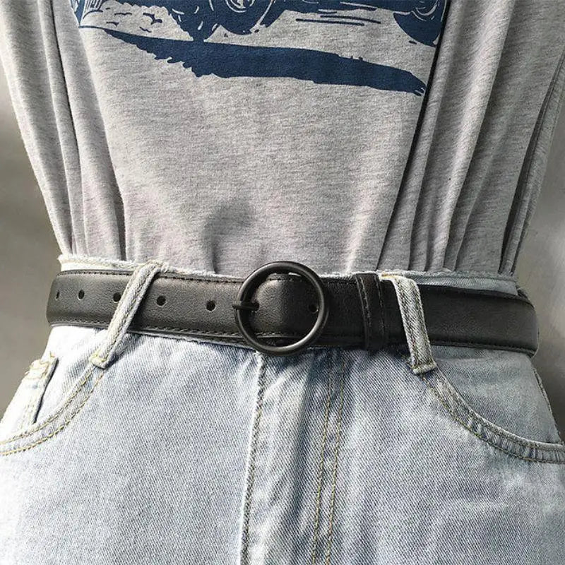 Black leather belt featuring a round metal buckle for a stylish and durable accessory