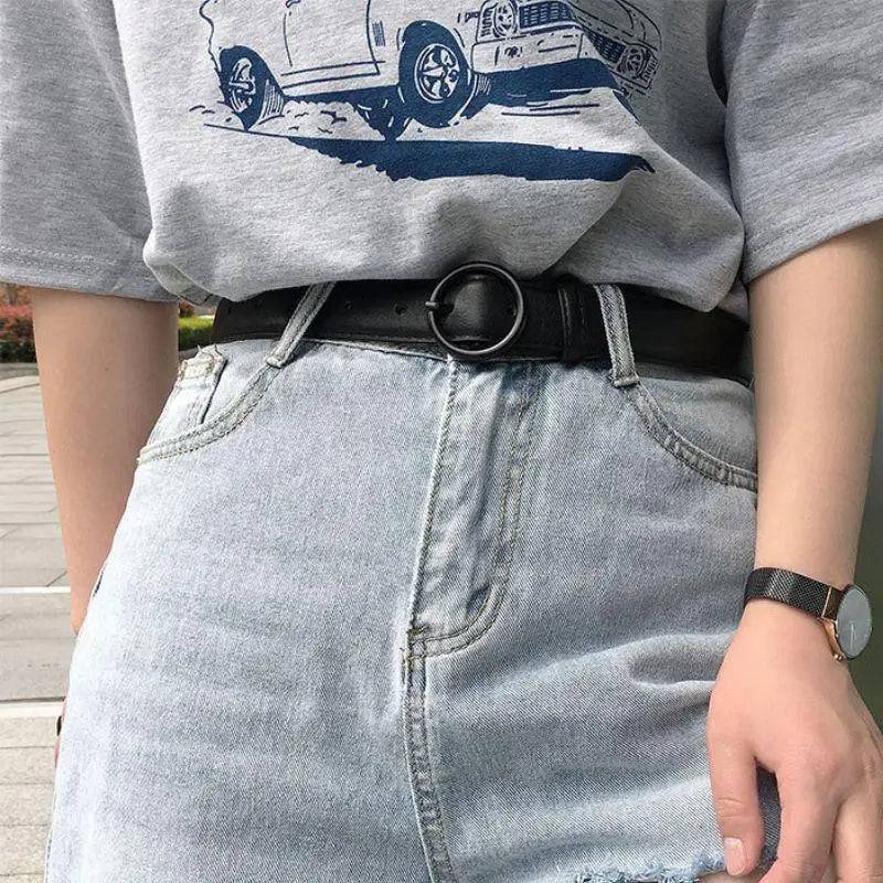Black leather belt featuring a stylish circular buckle suitable for formal and casual wear
