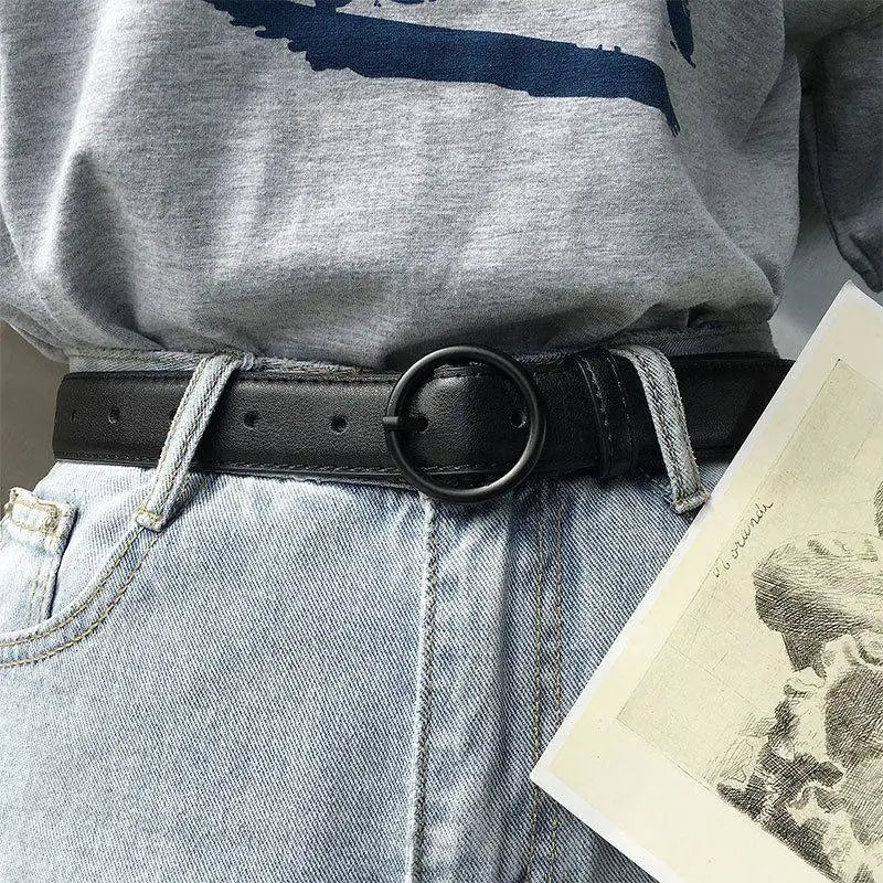 Black leather belt featuring a round buckle ideal for casual or formal wear
