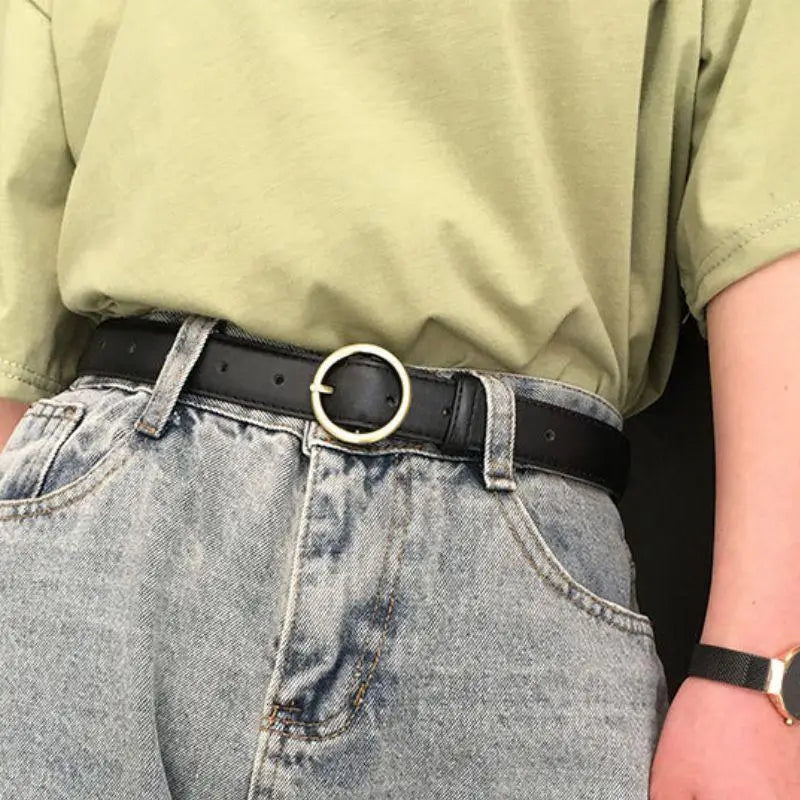 Person wearing a black leather belt with a gold round buckle in the product Black Leather Belt with Gold Round Buckle