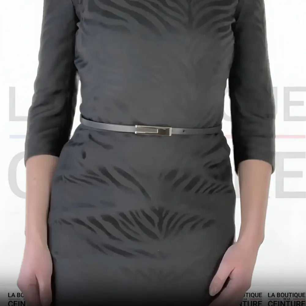 Gray women’s leather belt with gold buckle shown with a stylish dress