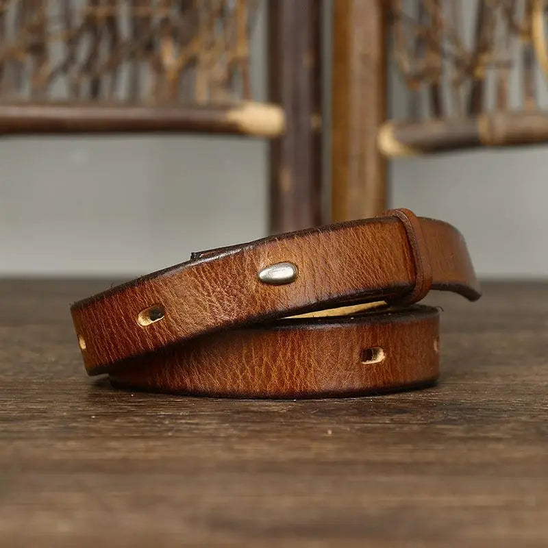 Brown leather belt with stitched edges and silver buckle displayed in product image