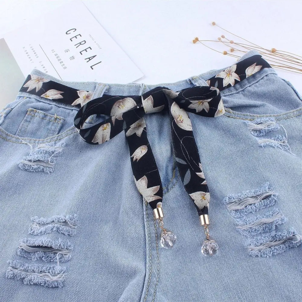 Distressed denim shorts with floral scarf belt for casual style and trendy look