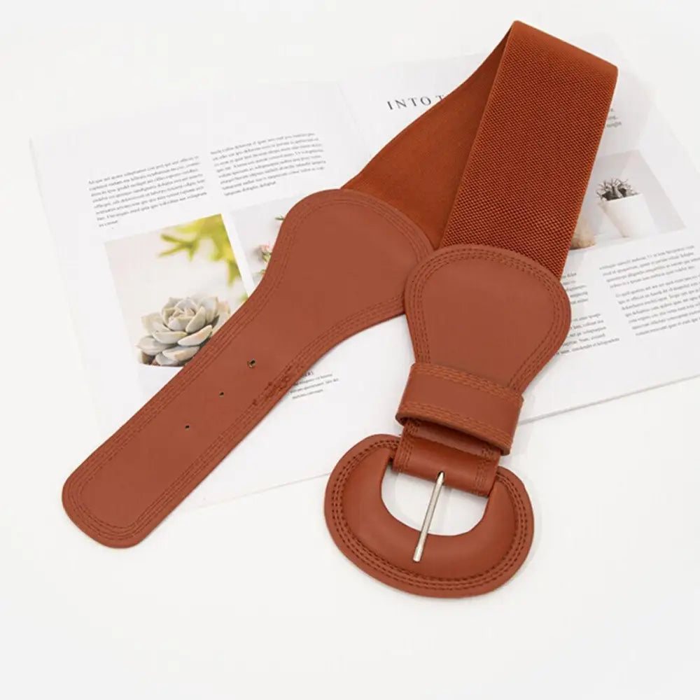 Brown elastic nikoline belt with circular buckle for stylish women’s outfits