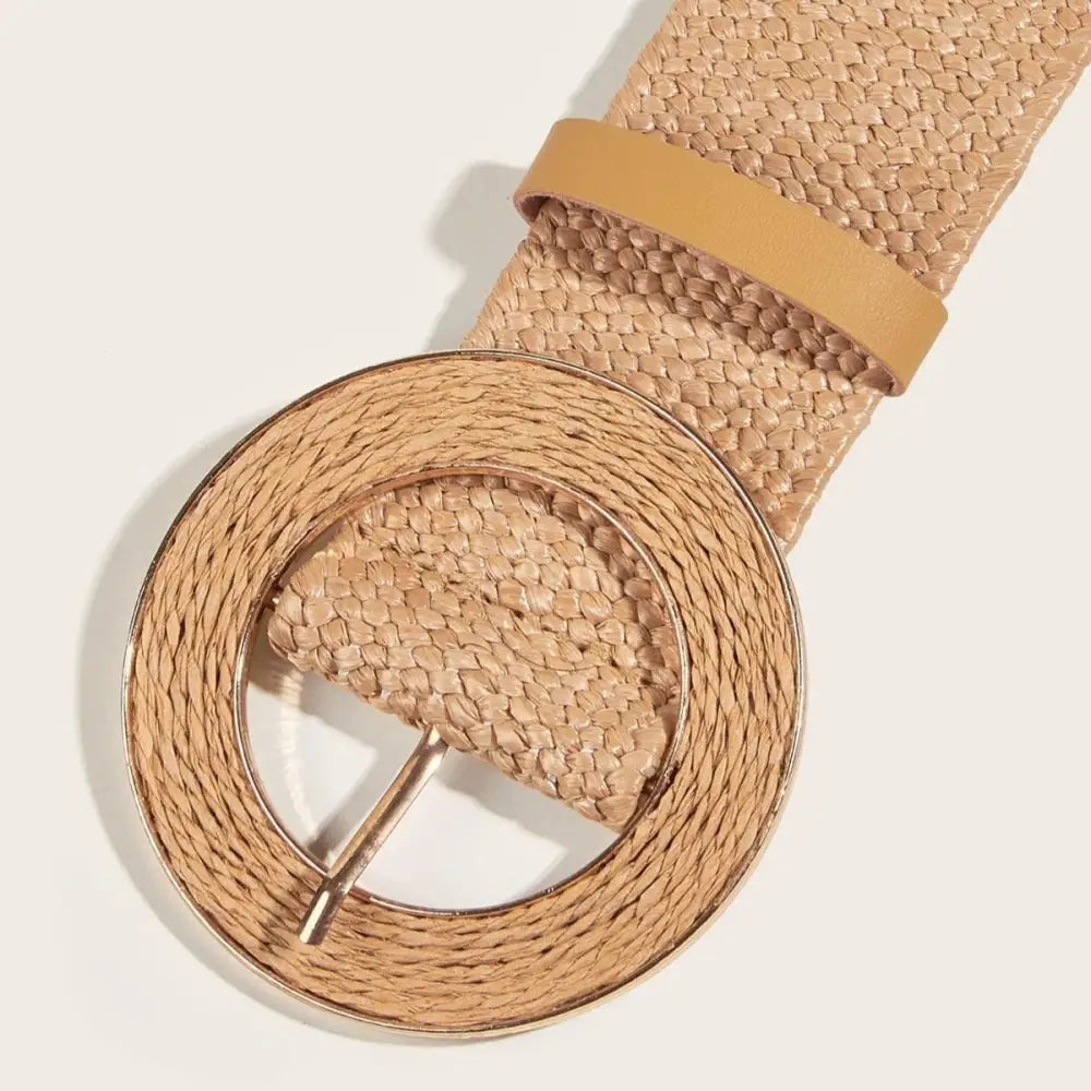 Woven tan straw raffia belt with circular buckle displayed in a product image