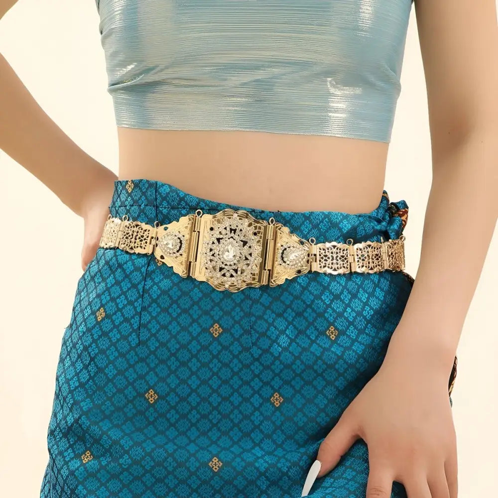 Elegant gold tone metal belt with intricate details and sparkling rhinestones