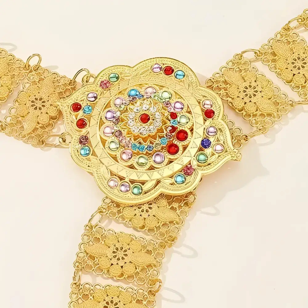 Gold-tone metal belt with jeweled flower buckle featuring colorful gem accents