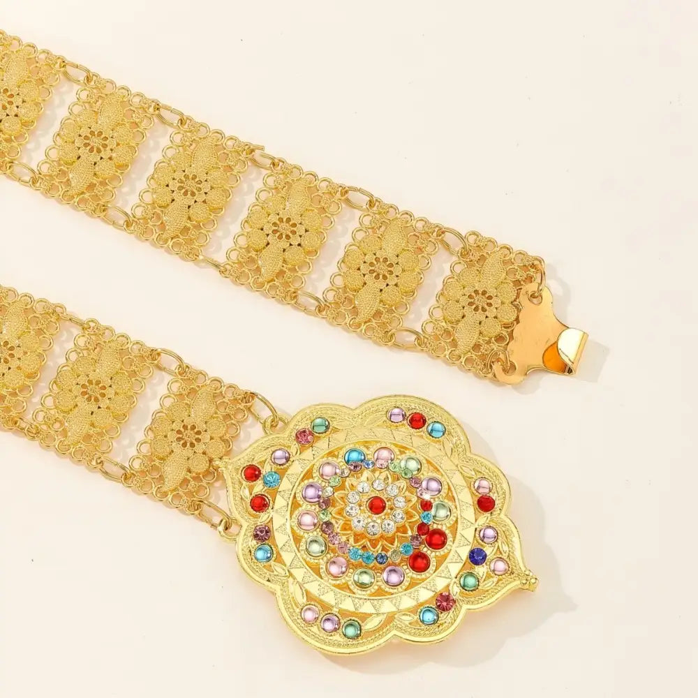 Gold-tone metal belt featuring a jeweled flower buckle accessory
