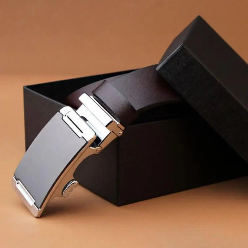Brown leather belt with silver buckle displayed in black box for classic style