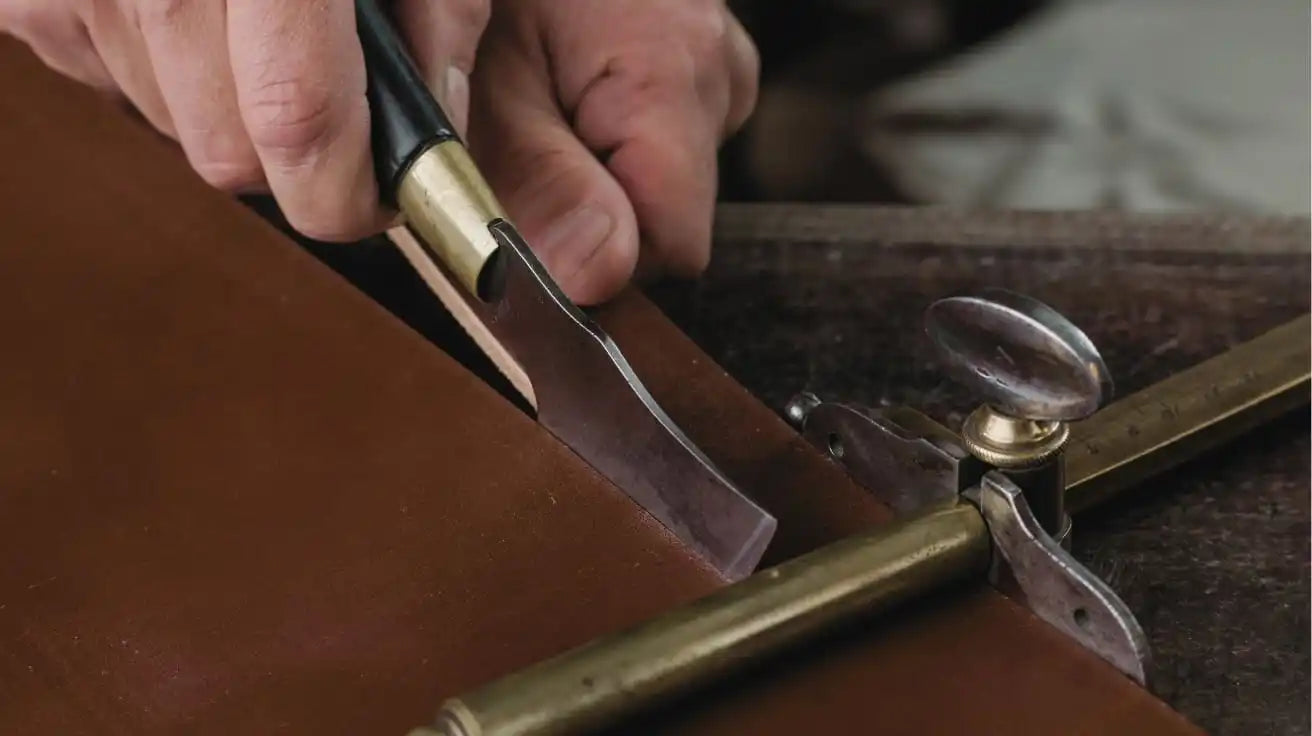 Leather-cutting tool with a curved blade.
