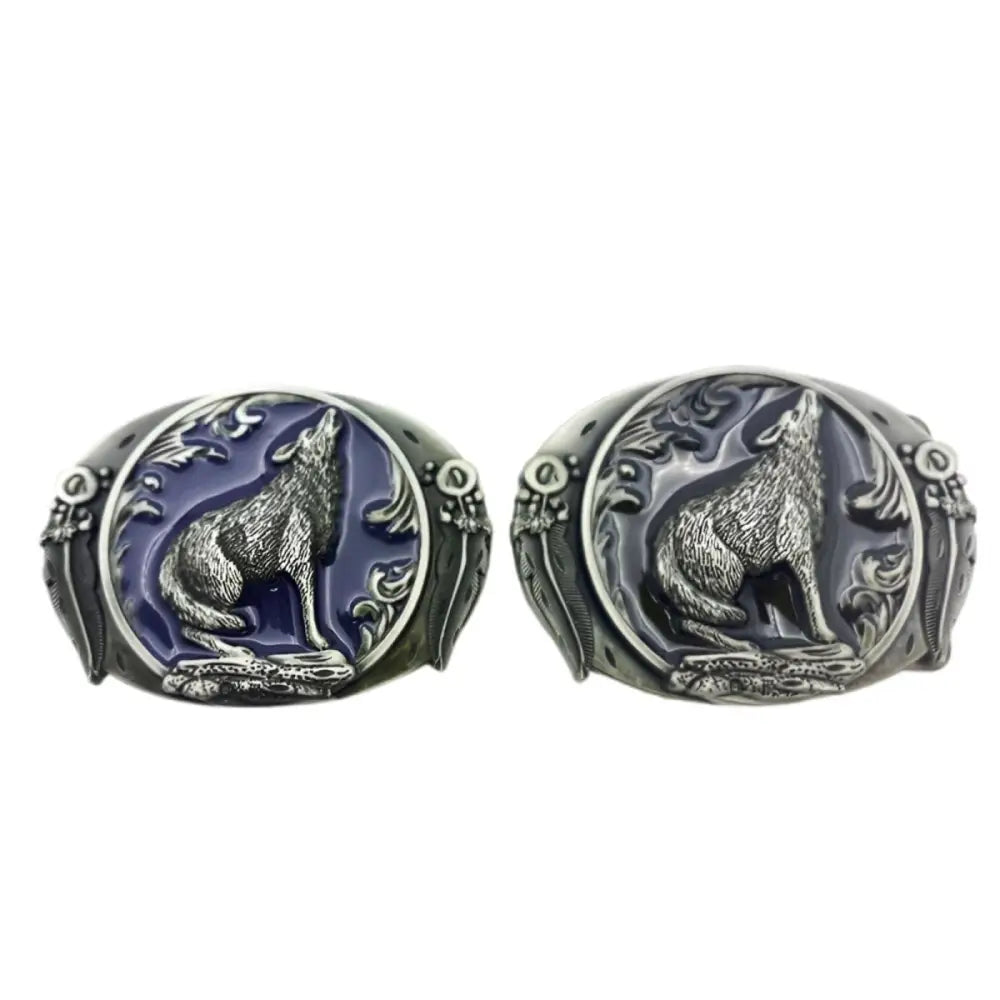 Two wolf-themed oval belt buckles with intricate howling wolf designs