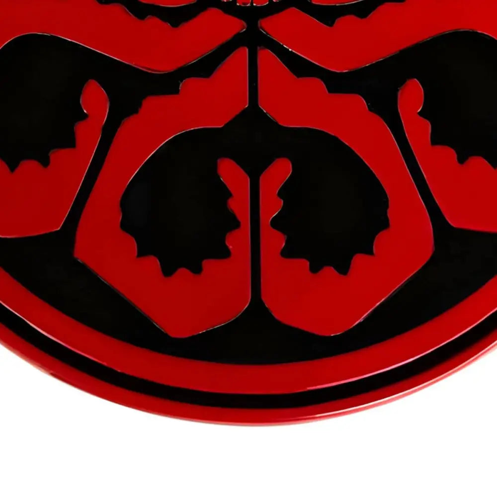 Red and black decorative emblem belt buckle featuring skull and octopus design