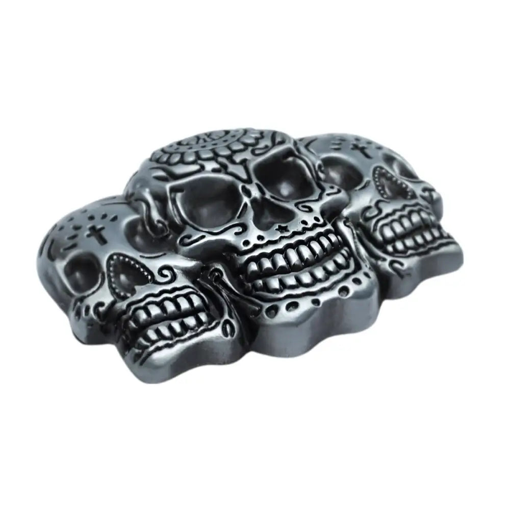 Silver belt buckle featuring three skulls and decorative metal design for a bold style