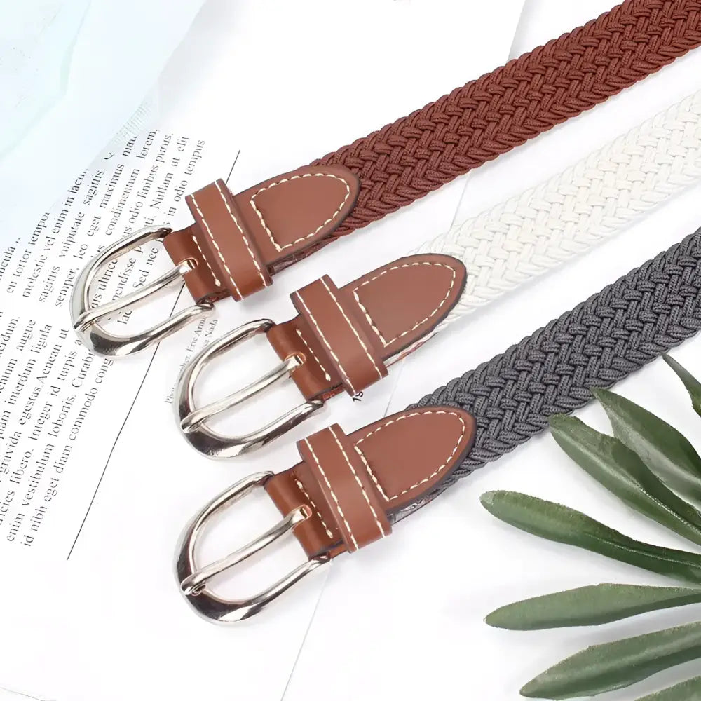 Three braided elastic belts with leather and silver buckles displayed for fashion accessory