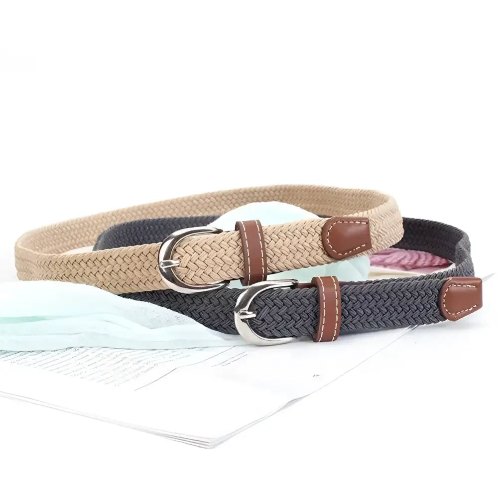 Braided elastic belt with leather accents and silver buckle displayed in product image