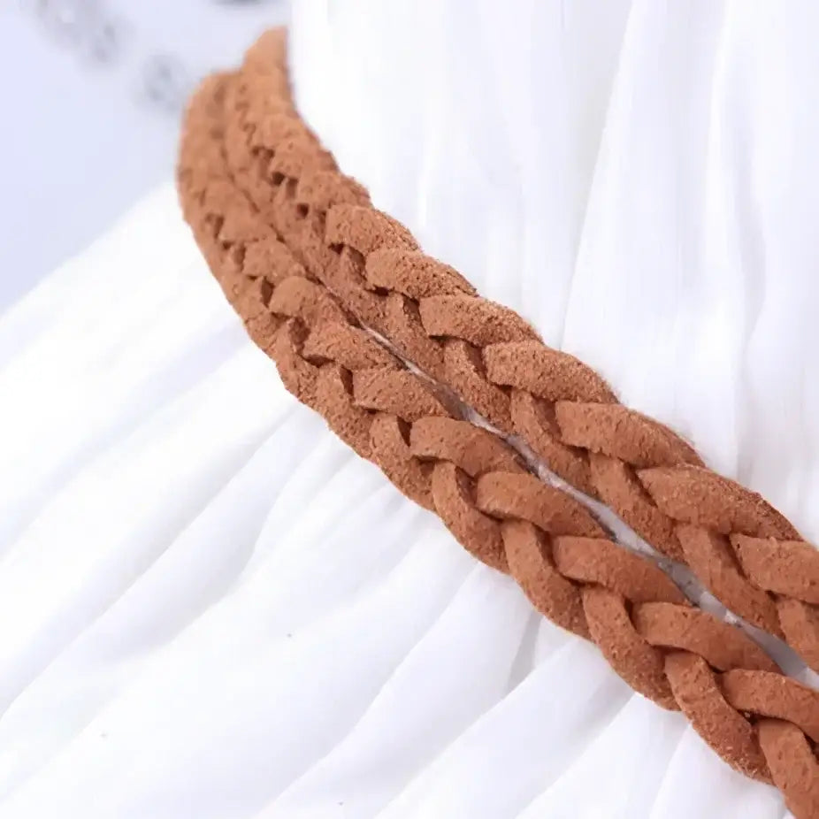 Brown braided belt with tassel detail on white fabric background for product listing
