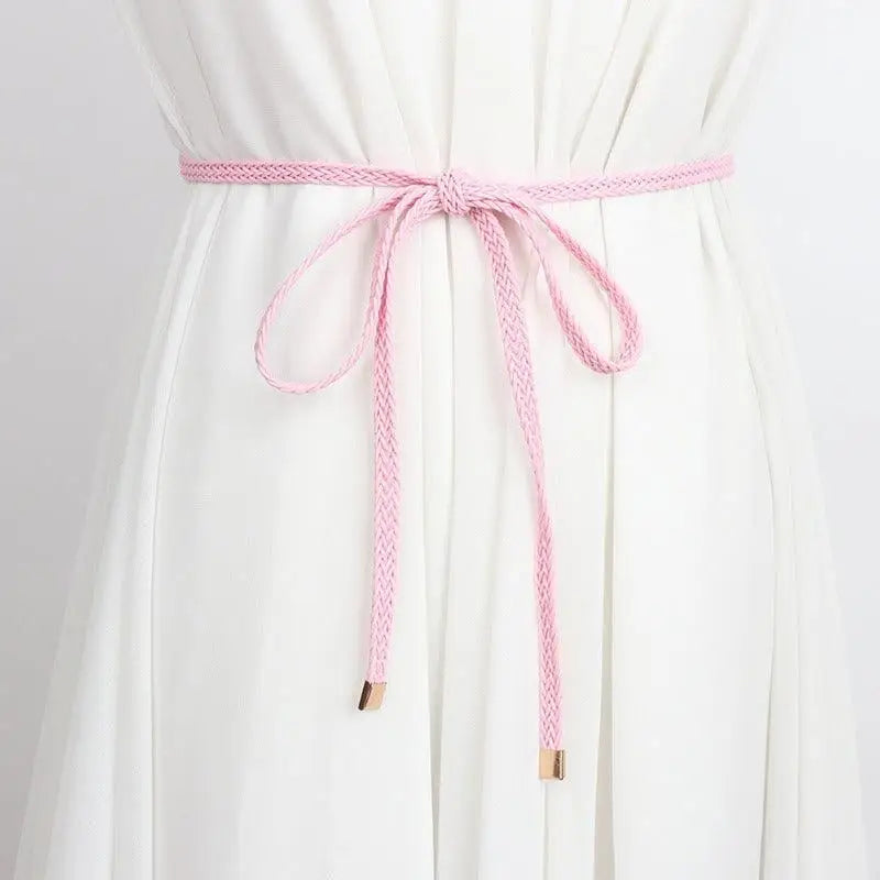 Pink braided belt styled with a white dress for a classic look