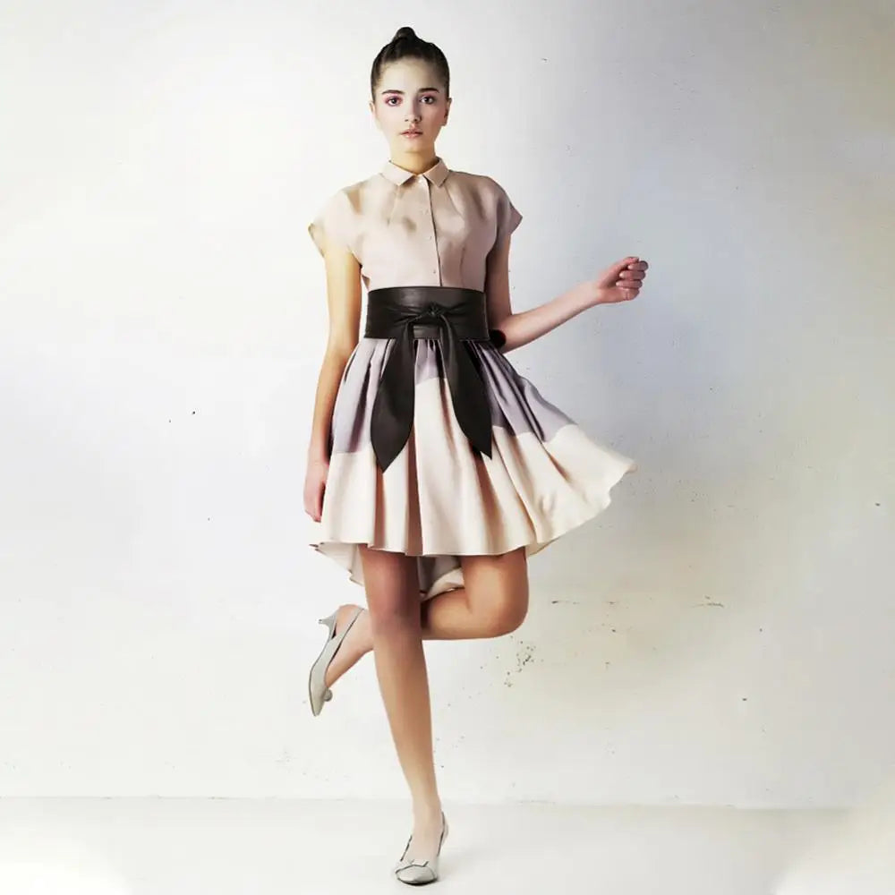 Woman wearing a beige dress with an Elly Belt in black leather for elegant style