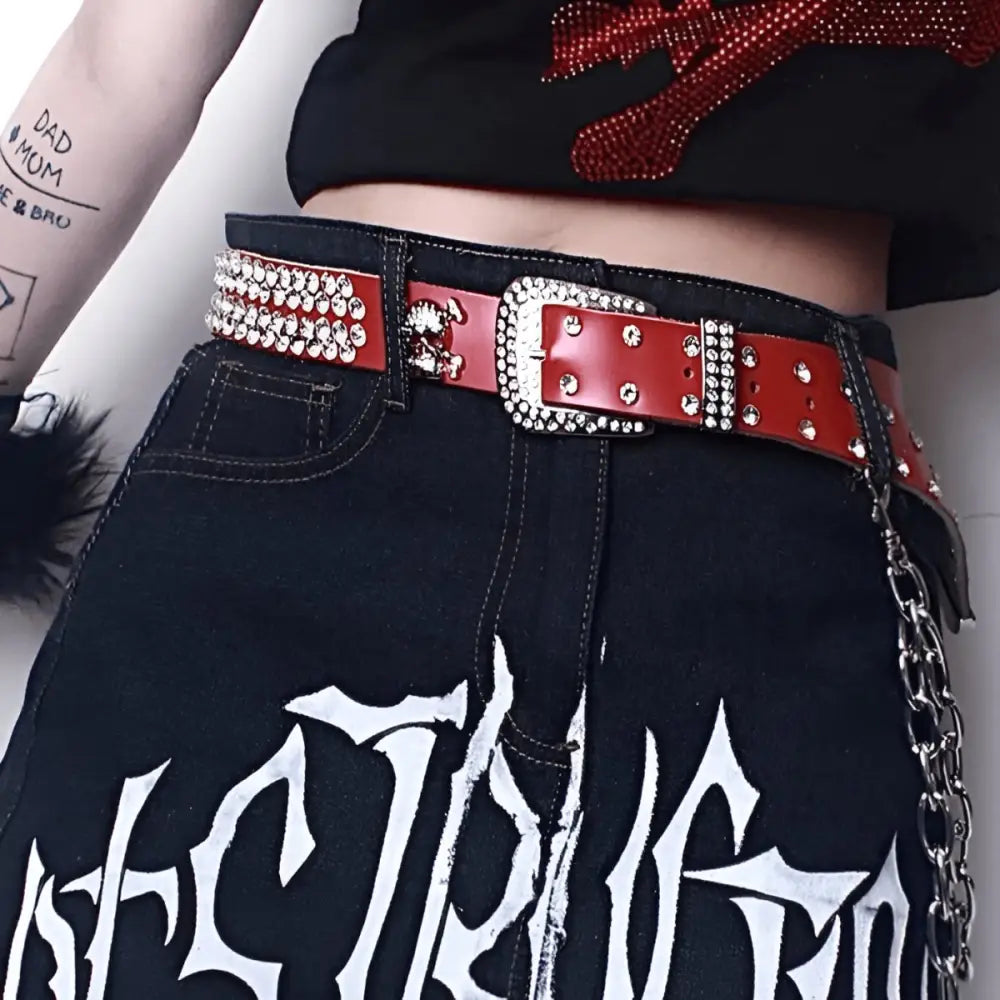 Red studded belt with skull detail from Zephyr Rhinestone Belt collection featuring genuine leather