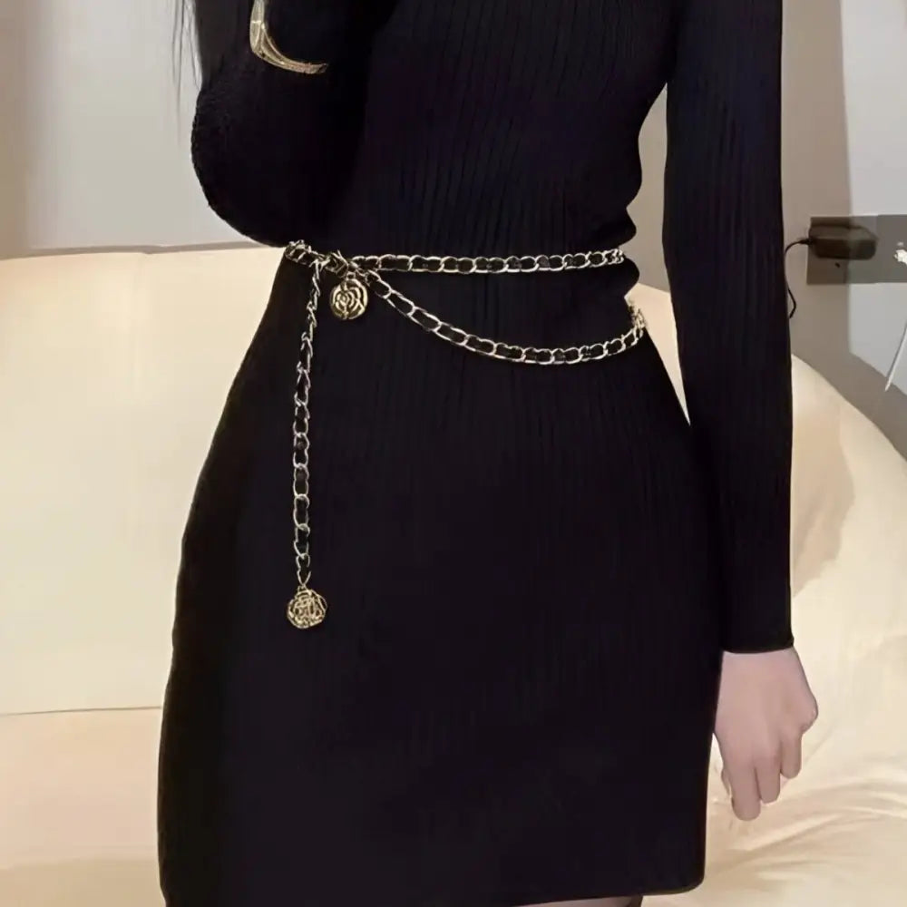 Black dress adorned with a gold rose-shaped chain belt for elegant evening wear