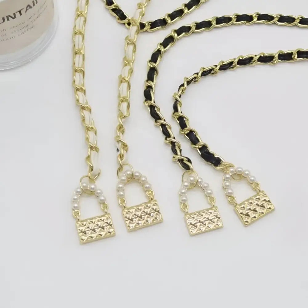 Gold chain purse straps complement Woman Black Pants with White Flower Chain Belt