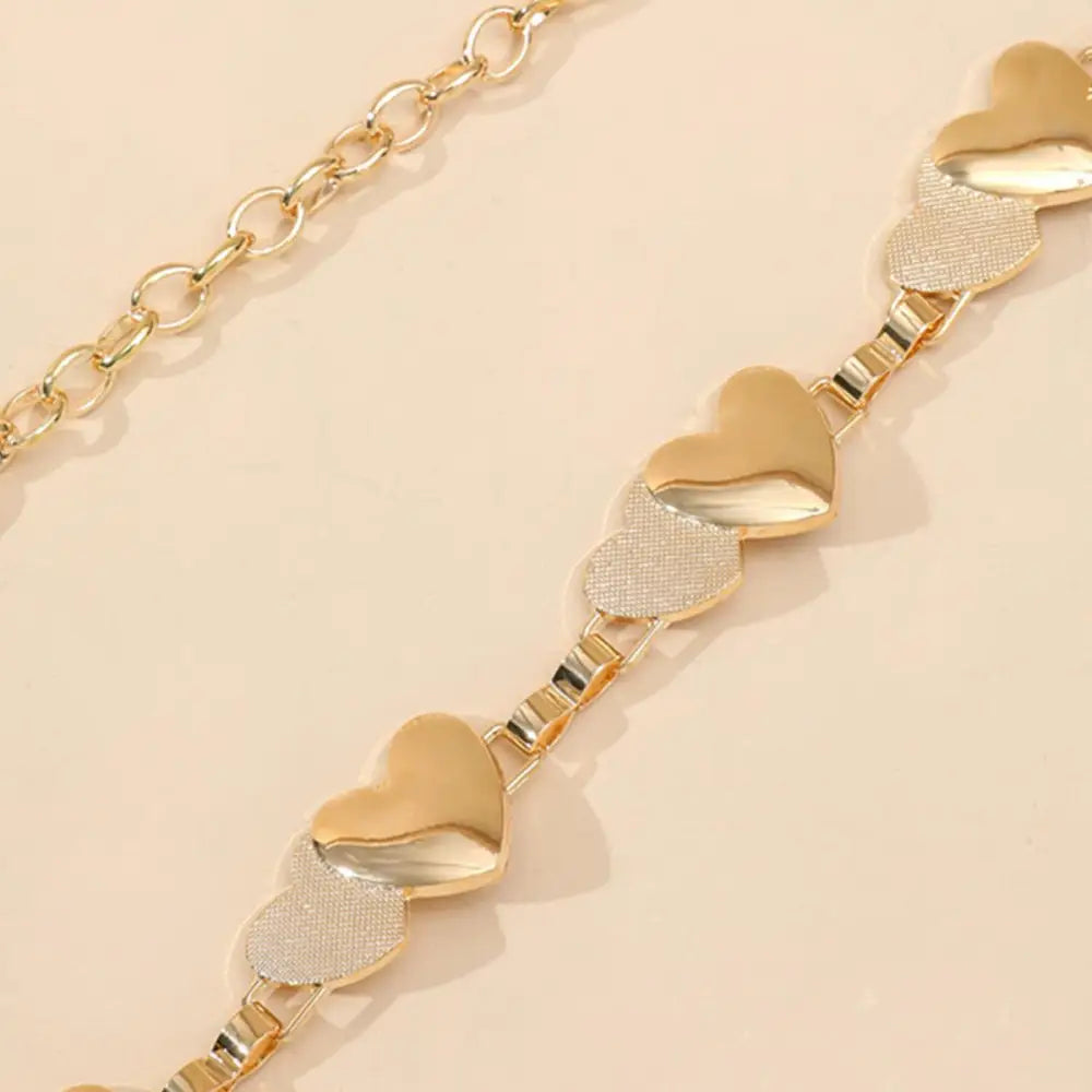 Gold-toned chain belt with heart-shaped accents for elegant style and sophistication