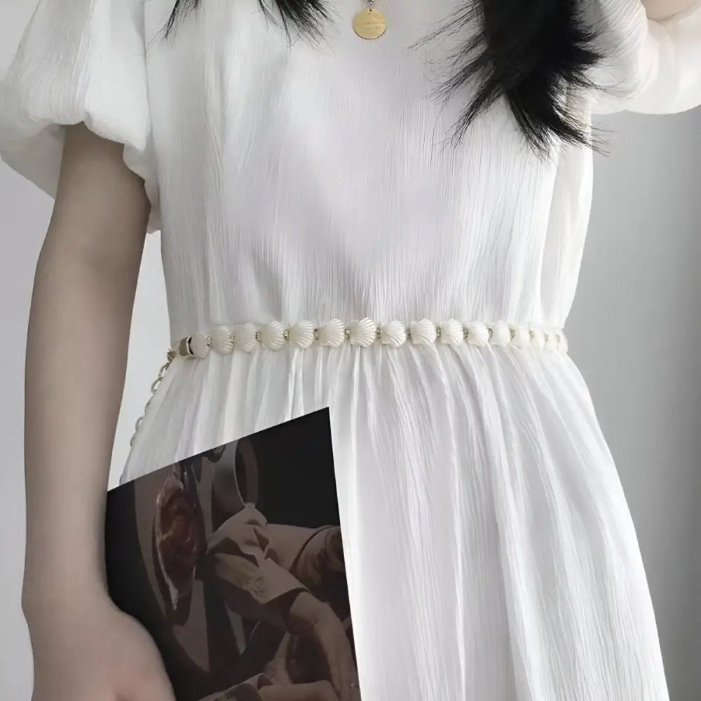 White dress with floral belt featuring a Vera Chain belt for elegant style
