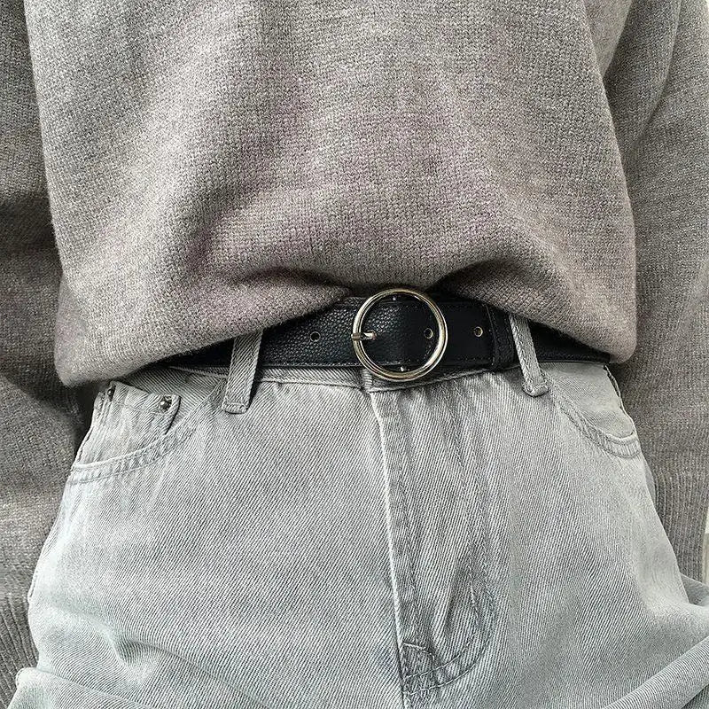 Gray sweater and jeans featuring the Murielle Belt Black Leather with Circular Silver Buckle