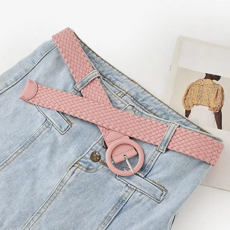 Light blue jeans paired with a pink braided belt featuring a round buckle for casual wear