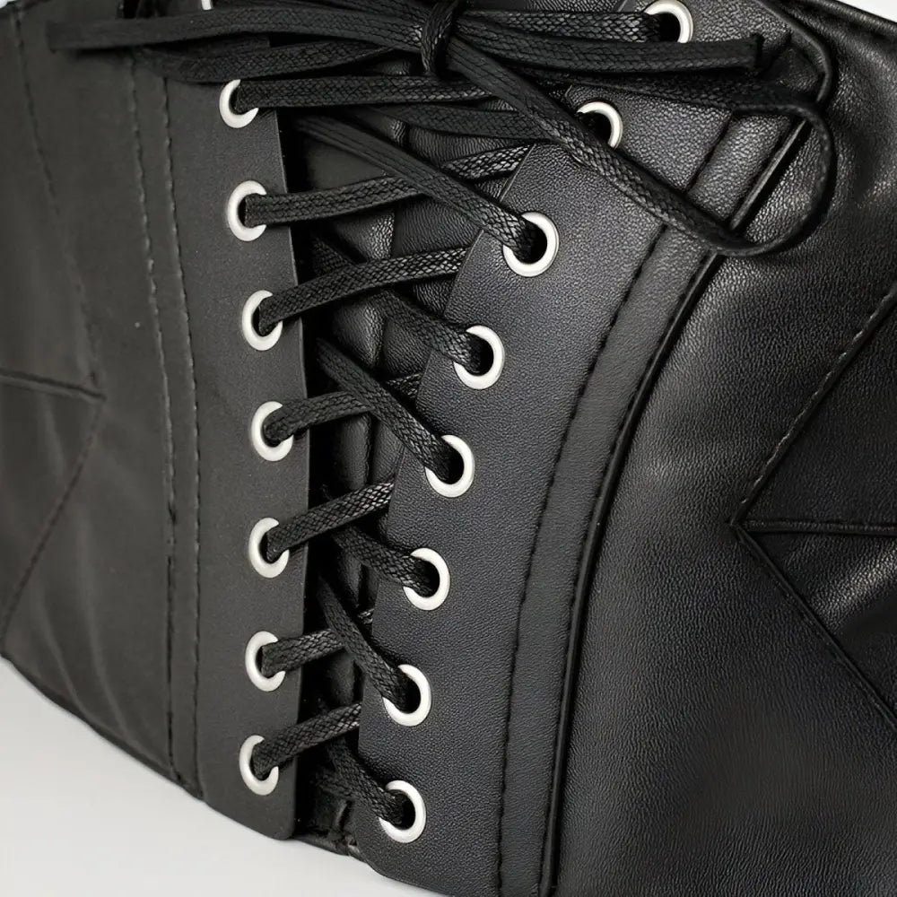 Black faux leather corset belt with silver grommets and lace-up design for a stylish look
