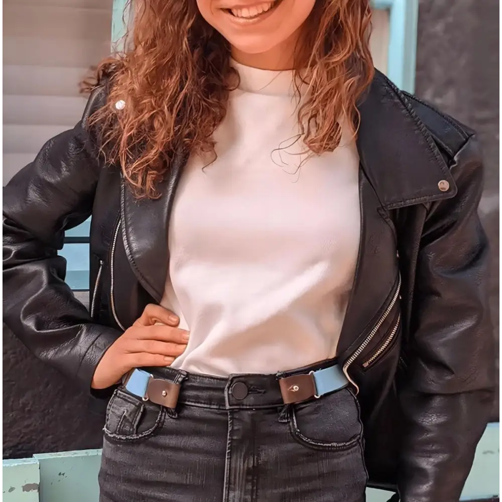 Woman wearing denim shorts with orange belt, pink polka dot suspenders, and black leather jacket