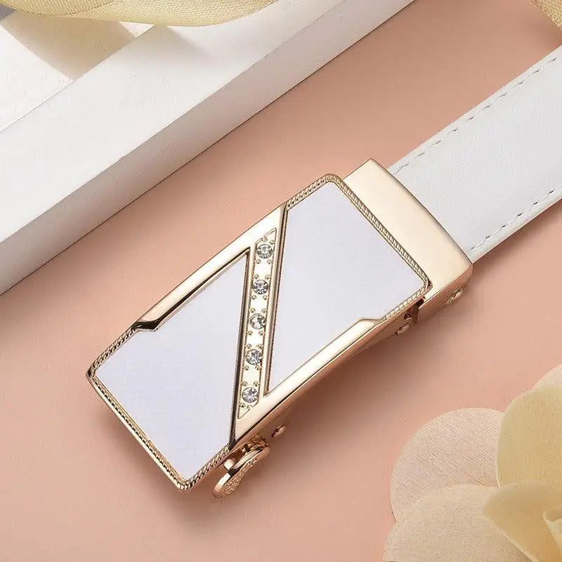 White leather belt featuring a gold and diamond-adorned decorative buckle