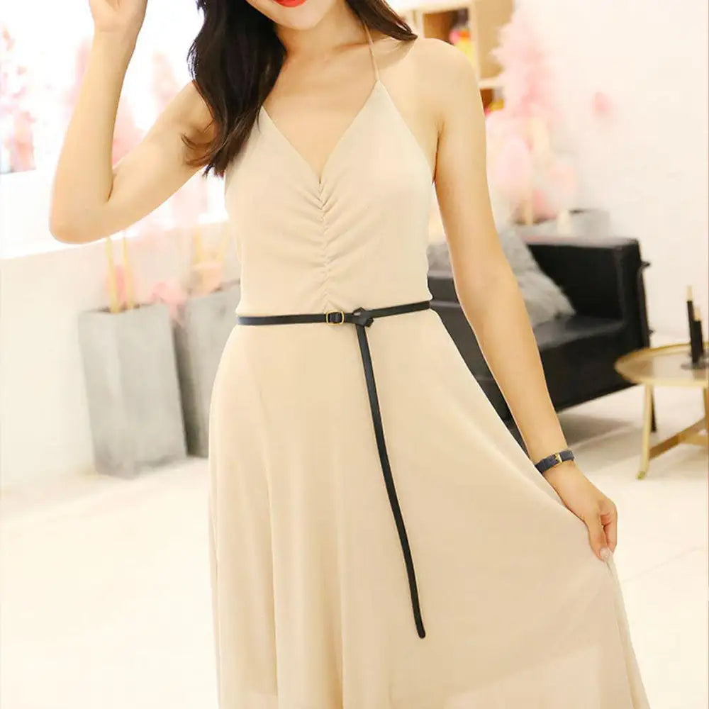 Sleeveless beige halter dress with a thin black belt and gold buckle for elegant style