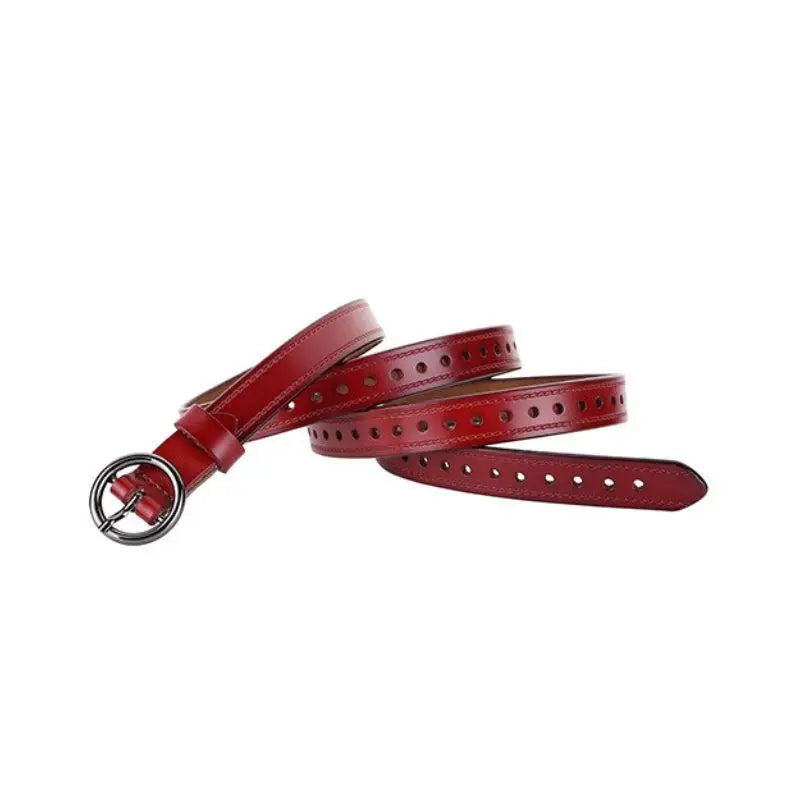 Red leather belt with silver buckle paired with a white cardigan featuring red and blue trim