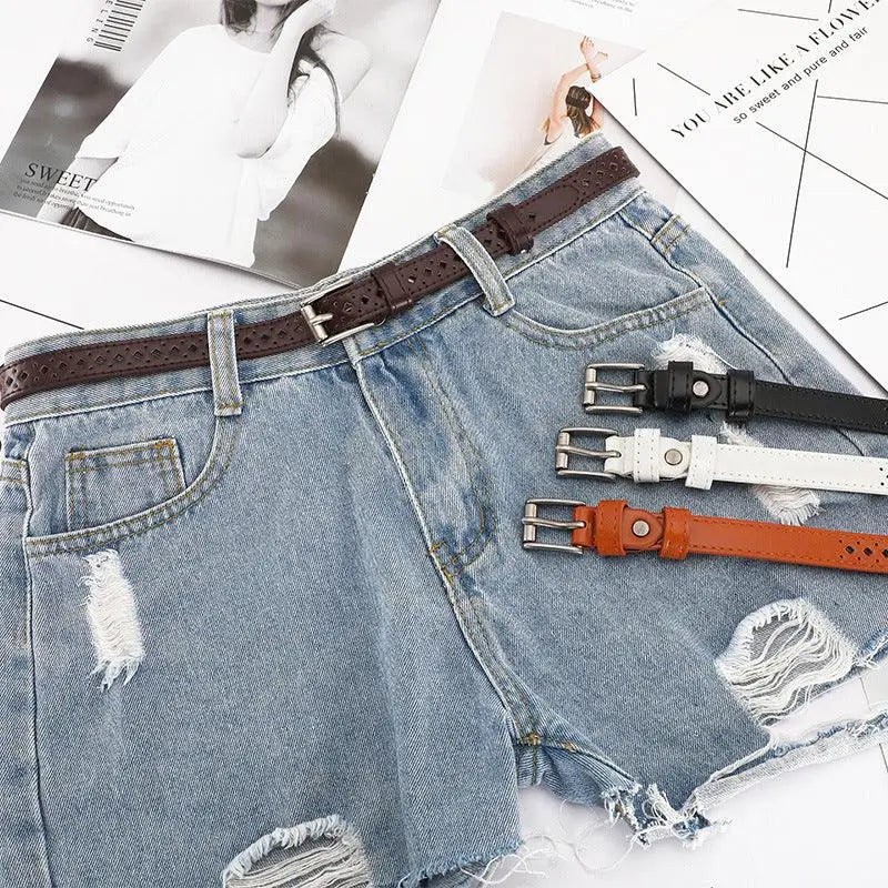 Distressed denim shorts with red leather belt featuring diamond cutouts for stylish wear