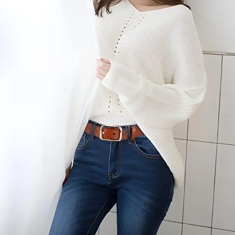 Woman’s outfit with white sweater blue jeans and a brown belt with a gold buckle