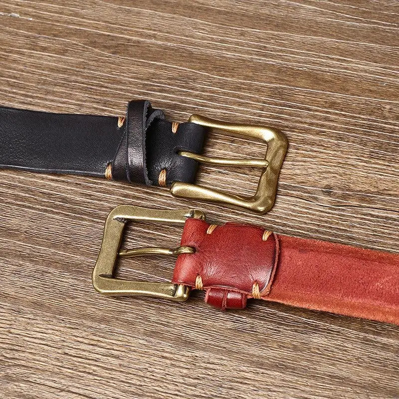 Red leather belts with brass buckles displayed in a stylish product presentation