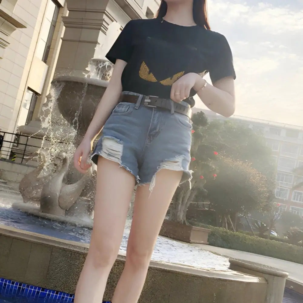 Woman wearing distressed denim shorts with Gulisa leather belt and red leather band